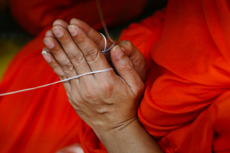 Sie nehmen an einem buddhistischen Ritual der Mönche teil.
