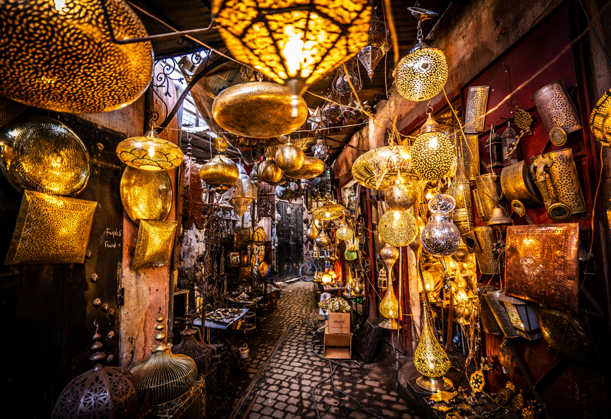 Auf dem Souk in Marrakesch bieten Händler Gewürze, traditionelle Handwerkskunst und Souvenirs an.