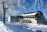 Das Panorama Berghotel Wettiner Höhe ist im Winter in einen weißen Mantel eingehüllt.