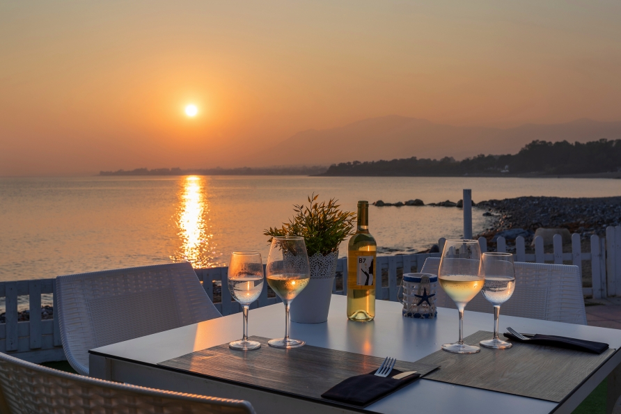 Genießen Sie den Sonnenuntergang bei einem Glas Wein in traumhafter Kulisse.