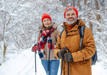 Unternehmen Sie eine winterliche Wanderung durch die verschneiten Wälder.