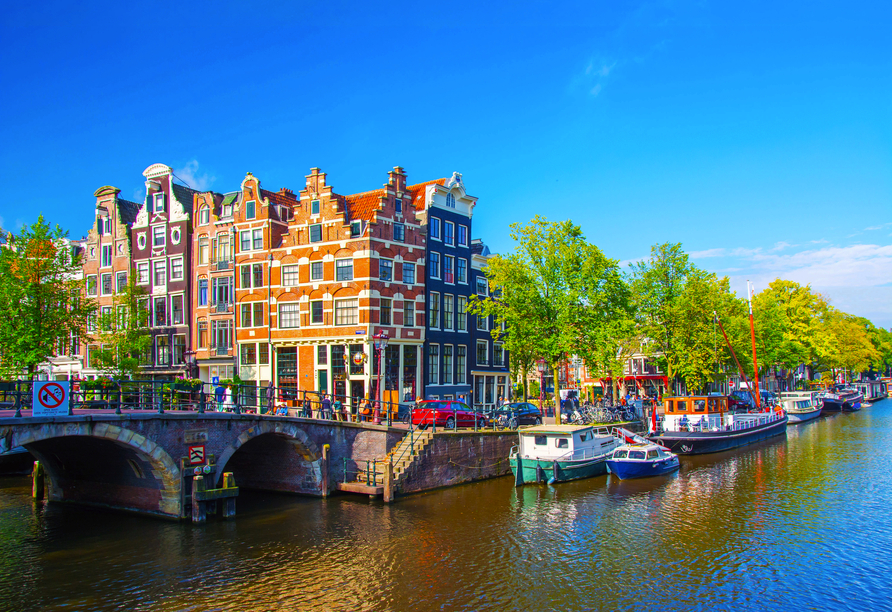Unternehmen Sie eine Grachtenfahrt durch das schöne Amsterdam.