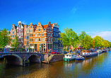 Unternehmen Sie eine Grachtenfahrt durch das schöne Amsterdam.