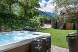 Der Wellnessgarten des Hotels mit Whirlpool und Sonnenliegen