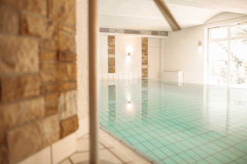 Das hoteleigene Hallenbad bietet ganzheitliche Erholung. | KI bearbeitet