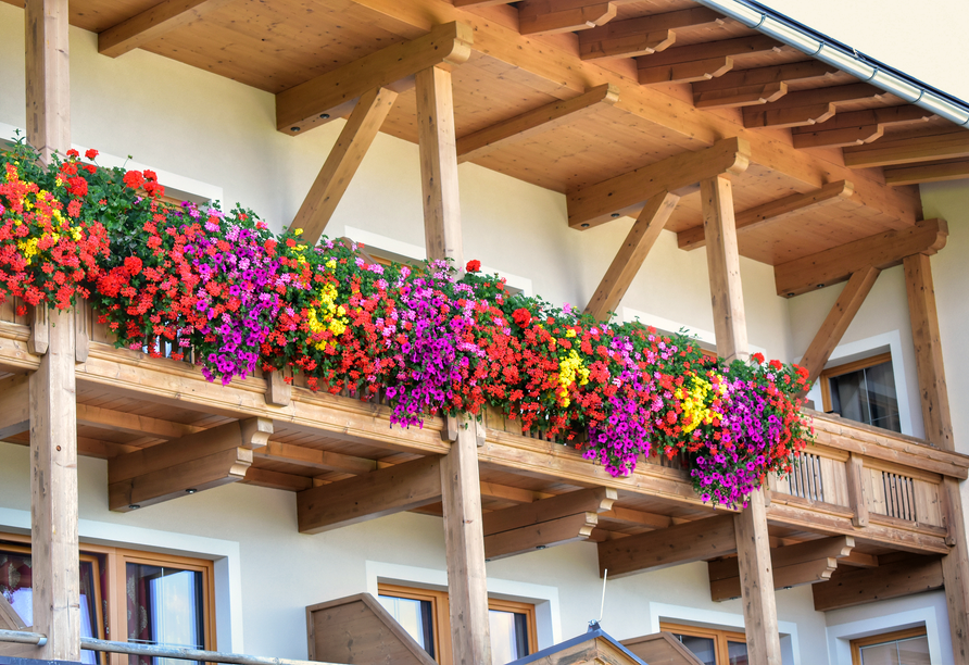 Eine herrliche Blumenpracht schmückt im Sommer die Fassade des Gasthofs Almhof.