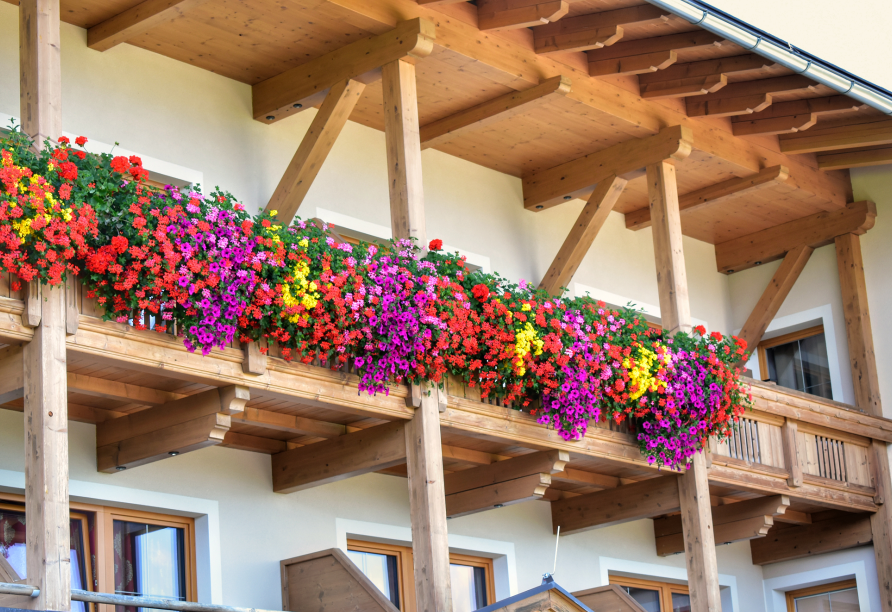 Eine herrliche Blumenpracht schmückt im Sommer die Fassade des Gasthofs Almhof.