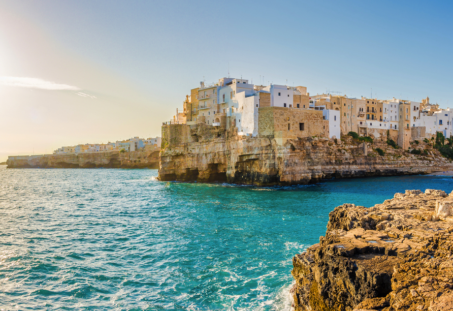 Sie besuchen die charmante Küstenstadt Polignano a Mare, die auf hohen Klippen über dem Meer thront.