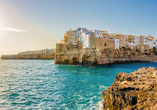 Sie besuchen die charmante Küstenstadt Polignano a Mare, die auf hohen Klippen über dem Meer thront.