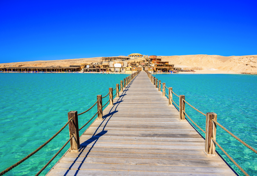 Freuen Sie sich auf eine Bootsfahrt zur Insel Orange Island, wo Sie ein weißer Sandstrand vor türkisfarbenem Meer erwartet.