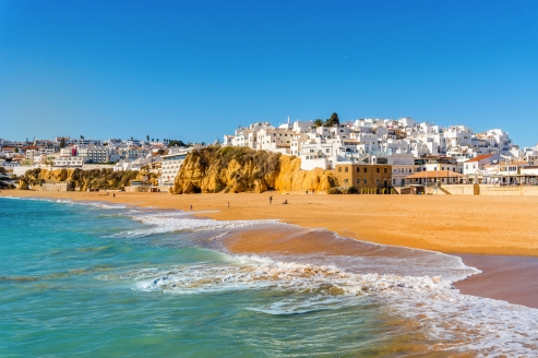 Genießen Sie entspannte Stunden am goldenen Sandstrand von Albufeira und lassen Sie sich vom Blick auf die strahlend weiße Altstadt verzaubern.