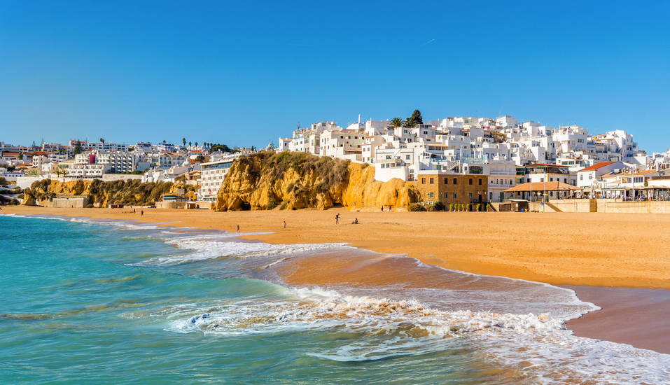 Genießen Sie entspannte Stunden am goldenen Sandstrand von Albufeira und lassen Sie sich vom Blick auf die strahlend weiße Altstadt verzaubern.