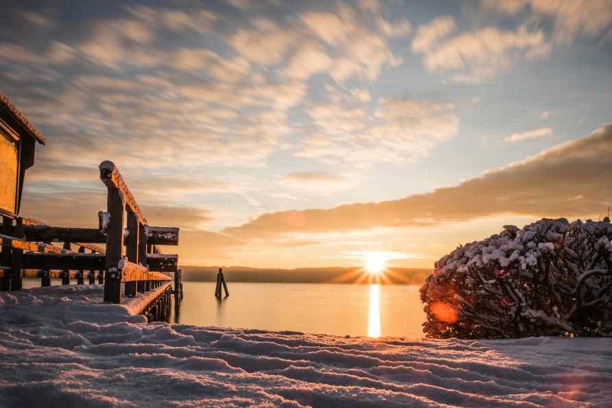 Die Sonne taucht den Ammersee im Winter in ein goldenes Licht – genießen Sie den Moment.