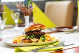 Genießen Sie im Restaurant kulinarische Highlights wie diesen saftigen Burger.