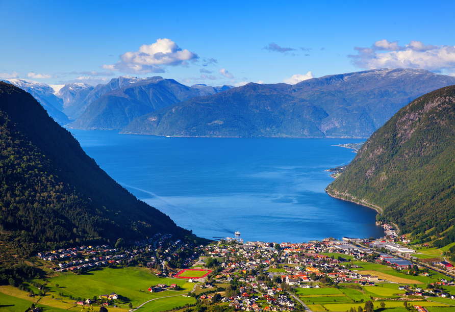 Vik liegt umgeben von grünen Bergen und dem blauen Meer.