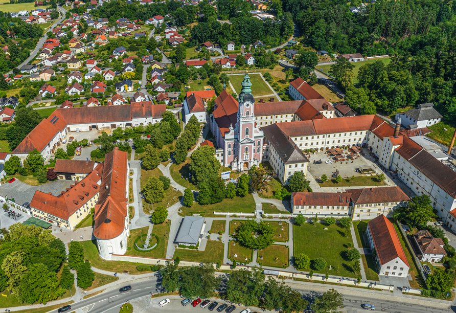 Luftaufnahme des Klosters Aldersbach in Bayern, umgeben von Grünflächen und weiteren Gebäuden.
