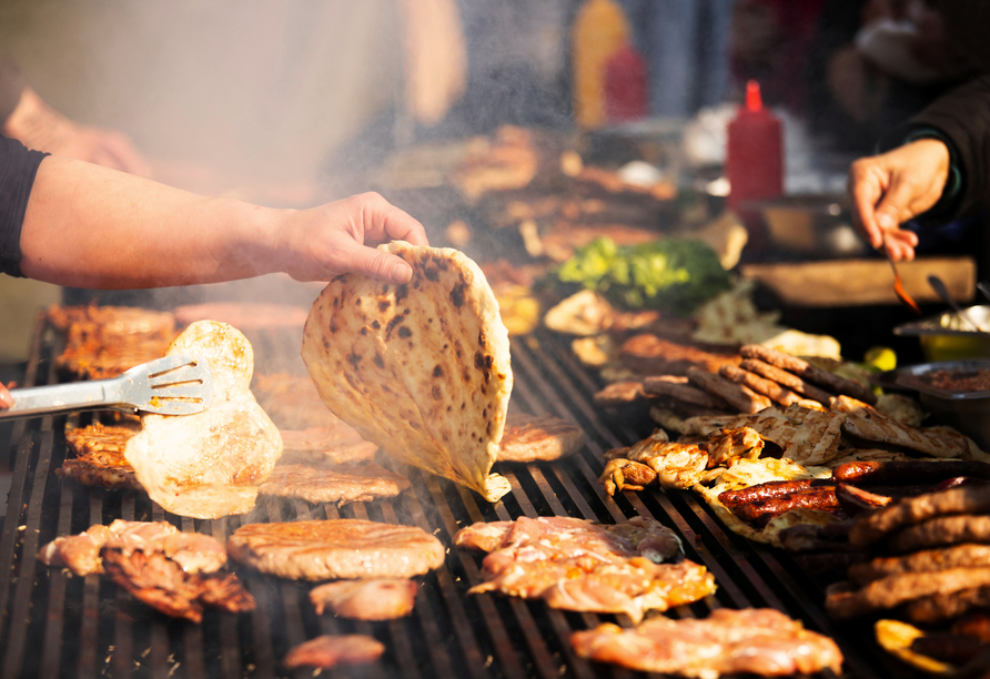 Probieren Sie regionale Köstlichkeiten vom Grill. 