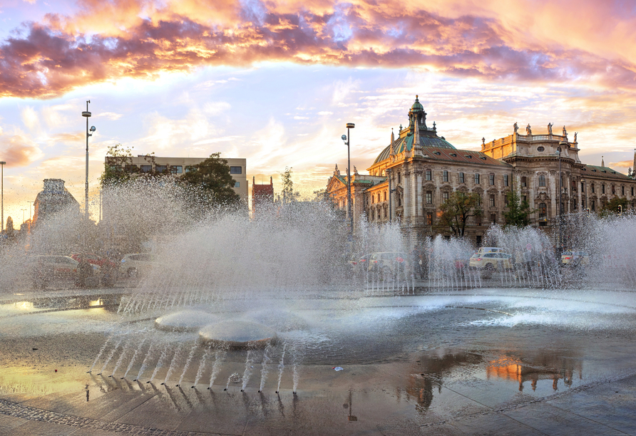 Brunnen am Karlsplatz, auch bekannt als Stachus, bei Sonnenuntergang mit Blick auf den Justizpalast