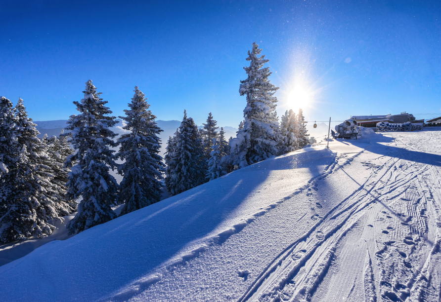 Die verschneite Tiroler Bergwelt bietet zahlreiche Freizeitmöglichkeiten, wie Skifahren, Winterwandern und vieles mehr.