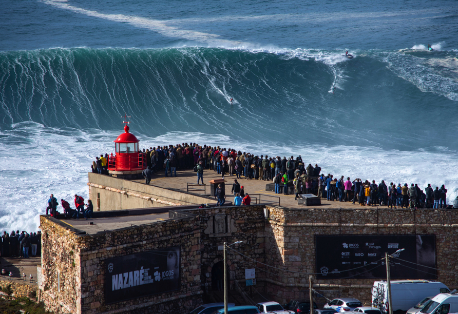 In Nazaré können Sie die Surfer auf dem tosenden Meer beobachten.