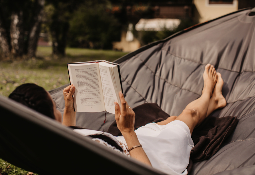 Schnappen Sie sich ein Buch, das sie in der Hängematte lesen können.