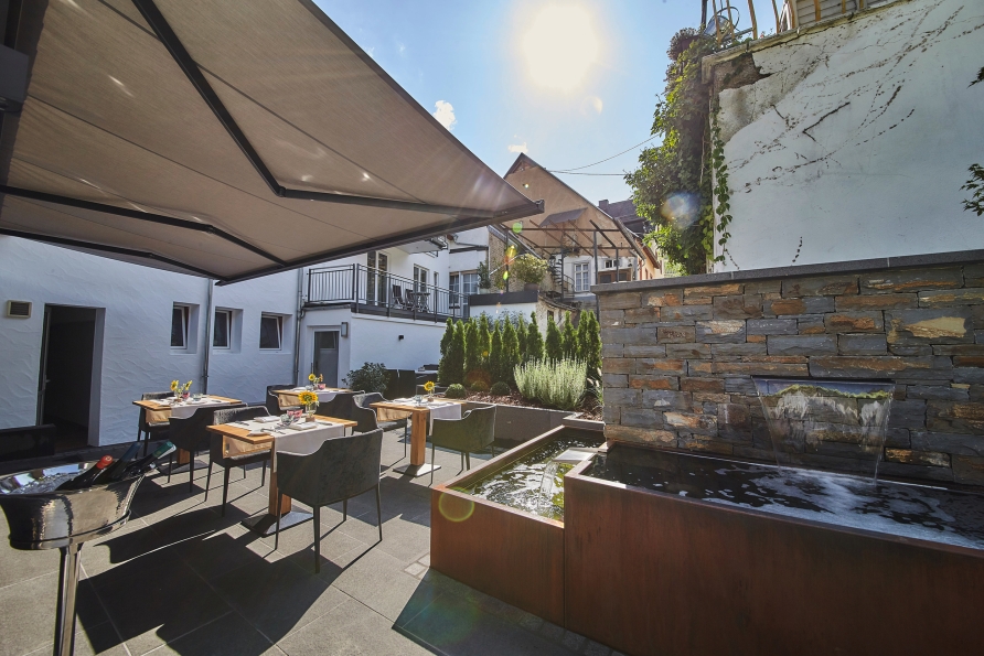 Lauschen Sie dem sanften Plätschern des Wassers, während Sie es sich auf der Terrasse gemütlich machen.