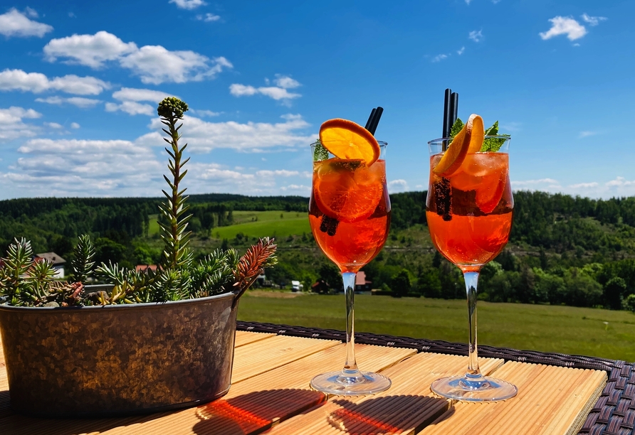 Lassen Sie es sich bei einem leckeren Aperol Spritz gutgehen und genießen Sie die sagenhafte Aussicht auf den Harz.