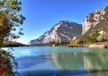 Ein Ort wie aus dem Bilderbuch: Der romantische Lago di Toblino, umgeben von üppiger Natur und Weinbergen.