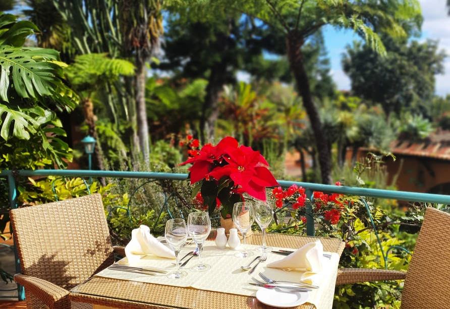 Nehmen Sie auf der schönen Terrasse mitten im Grünen Platz und genießen Sie köstliche Speisen.