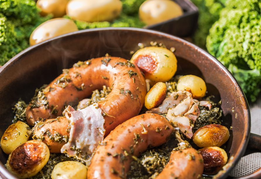 Grünkohl mit Bregenwurst und Röstkartoffeln ist eine Spezialität in Norddeutschland.