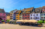 Hübsche bunte Fachwerkhäuser zieren den lebhaften Place de la Réunion in Mülhausen.