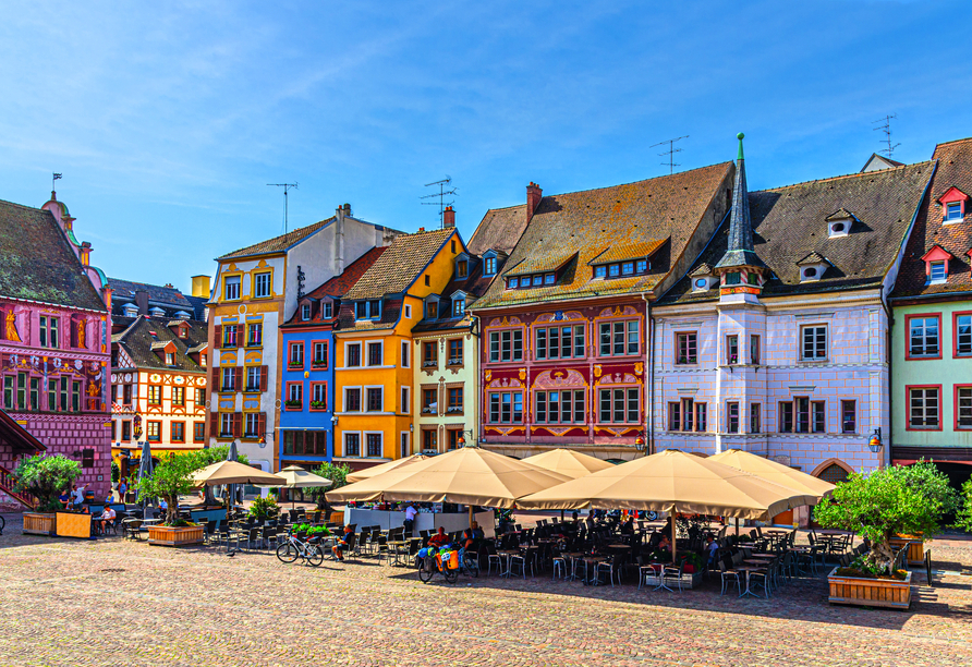 Hübsche bunte Fachwerkhäuser zieren den lebhaften Place de la Réunion in Mülhausen.