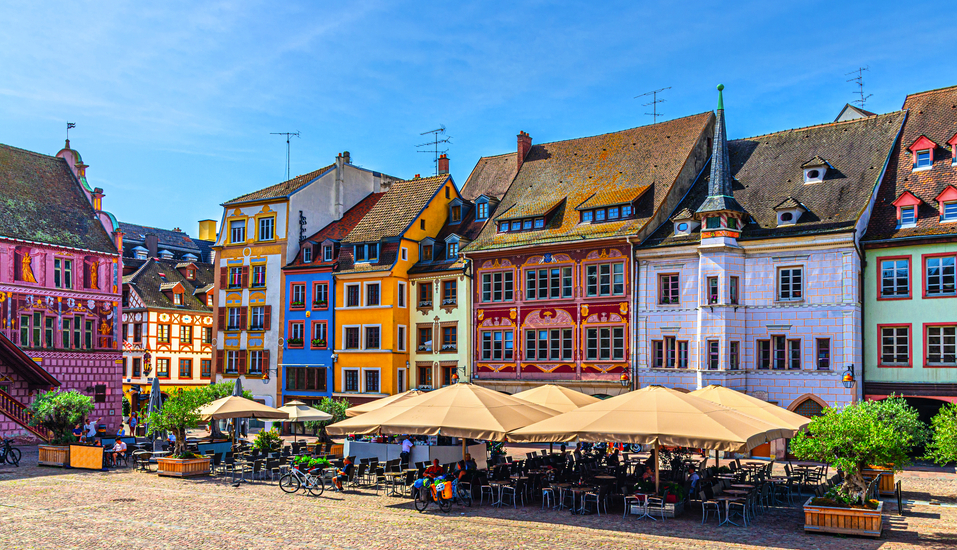 Hübsche bunte Fachwerkhäuser zieren den lebhaften Place de la Réunion in Mülhausen.