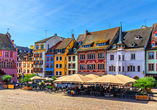 Hübsche bunte Fachwerkhäuser zieren den lebhaften Place de la Réunion in Mülhausen.