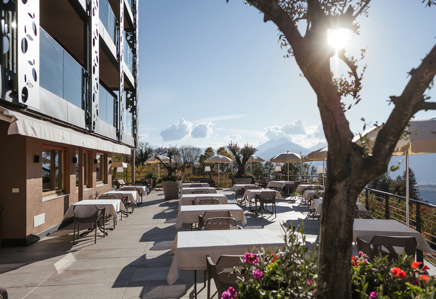 Genießen Sie auf der Hotelterrasse die Sonne Italiens und das atemberaubende Bergpanorama.