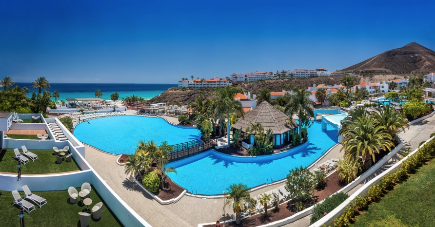 Die weitläufige Poollandschaft mit tropischem Flair und herrlicher Aussicht auf die Küste.