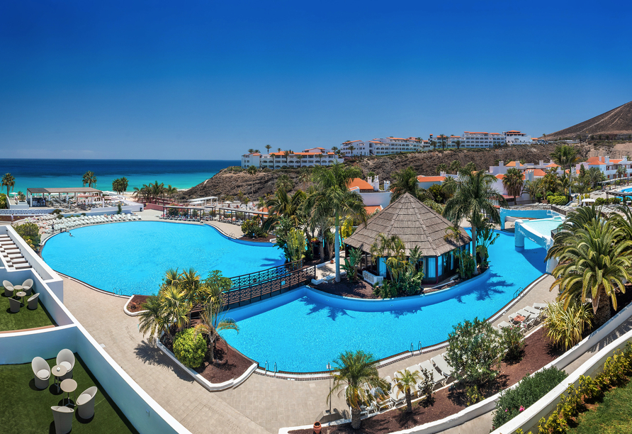 Die weitläufige Poollandschaft mit tropischem Flair und herrlicher Aussicht auf die Küste.