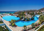 Die weitläufige Poollandschaft mit tropischem Flair und herrlicher Aussicht auf die Küste.