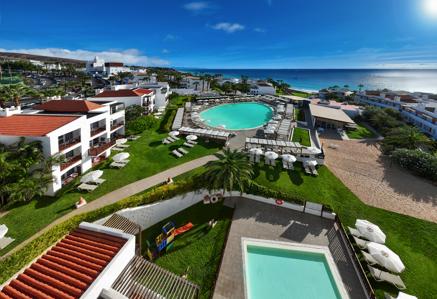 Herrlicher Blick auf die Poollandschaft und das grüne Hotelgelände