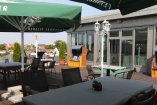 Entspannen Sie auf der sonnigen Hotelterrasse mit kühlen Getränken, bequemen Sitzplätzen und sommerlicher Atmosphäre.