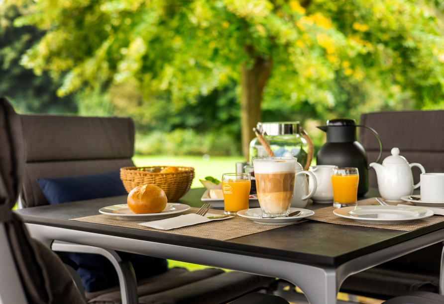 Genießen Sie die ersten Sonnenstrahlen bei einem Frühstück auf der Terrasse.