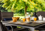 Genießen Sie die ersten Sonnenstrahlen bei einem Frühstück auf der Terrasse.