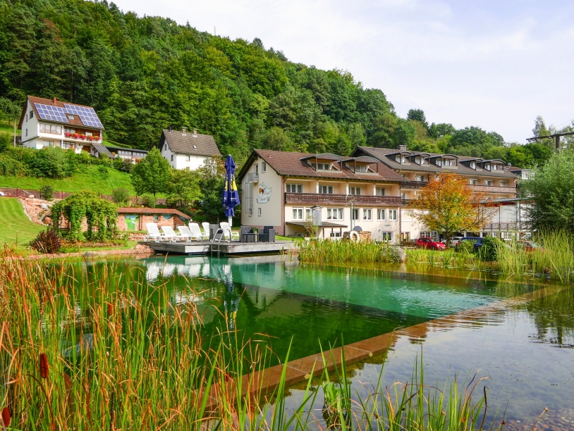 Außenansicht vom Hotel Christel mit dem großen Naturbadeteich