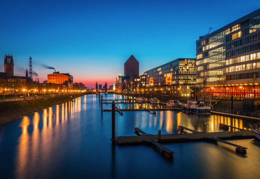 Duisburgs Innenhafen bietet ein spektakuläres Panorama am Abend.