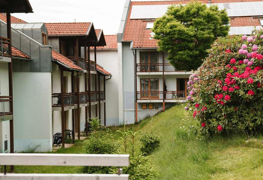 Genießen Sie einen Spaziergang durch den blühenden Garten des Hotels.