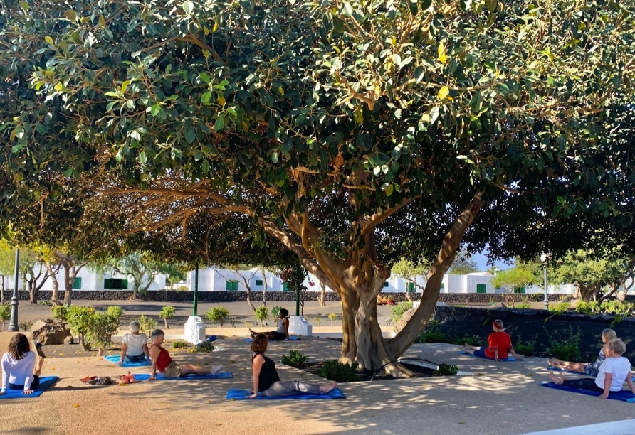 Entspannen Sie beim Yoga im Garten des Hotels.
