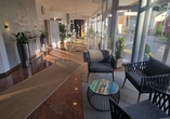 Blick in die moderne Hotellobby mit gemütlicher Sitzgelegenheit.