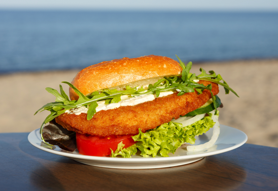 Genießen Sie ein leckeres Fischbrötchen mit Meerblick.