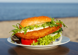 Genießen Sie ein leckeres Fischbrötchen mit Meerblick.