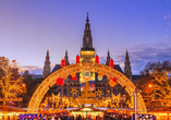 Die Lichter des Christkindlmarkts am Rathausplatz tauchen den Platz in ein warmes Licht.